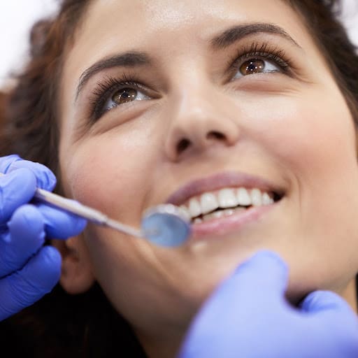 Woman in dental chair looking at her dentist right before scaling and root planing in Danvers