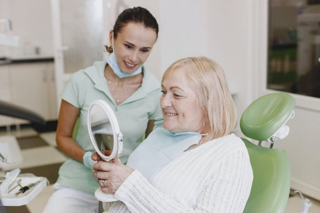 Woman at dental office looking at mirror after dental restoration