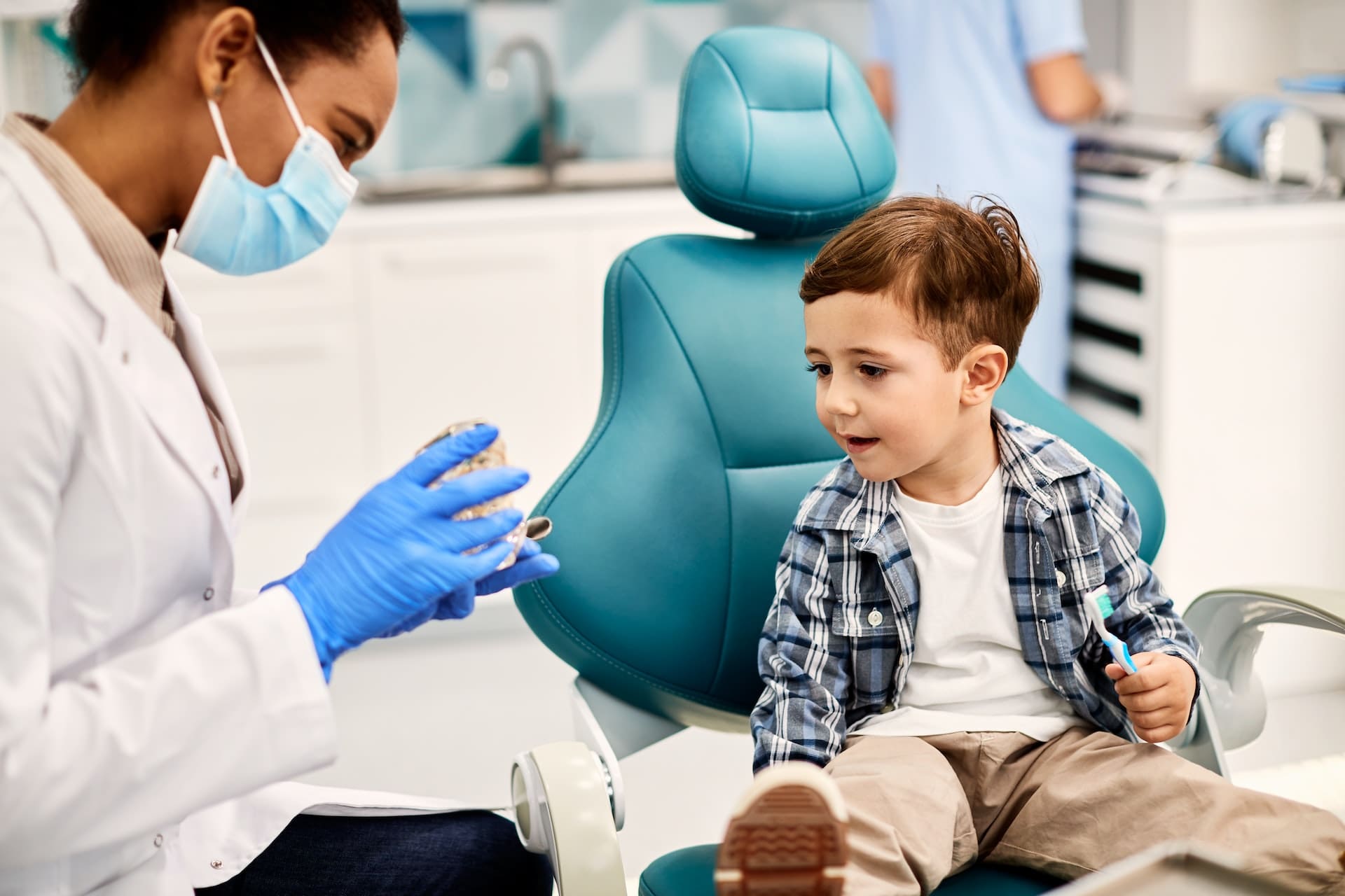 Dentist showing child a teeth model