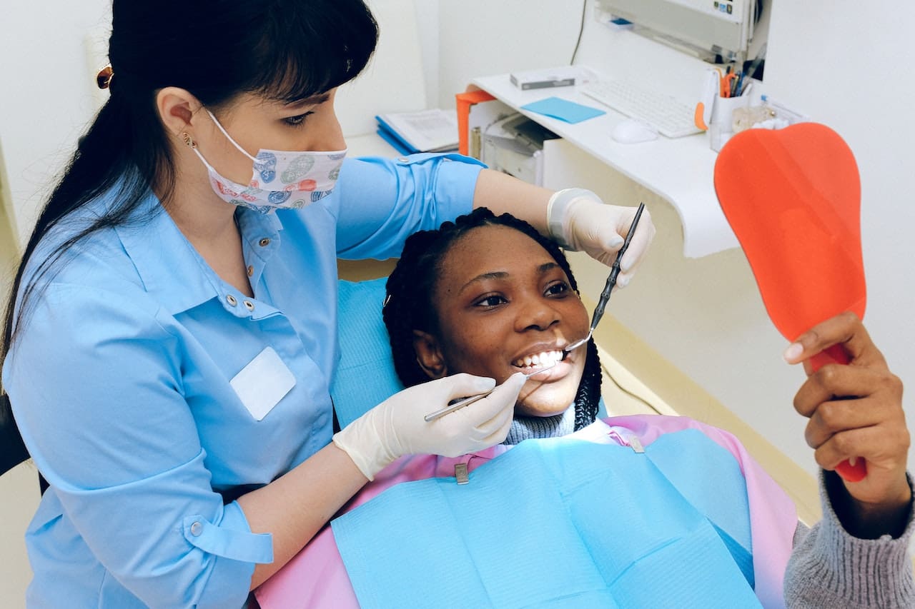 Patient looking in mirror while reclining on dental chair