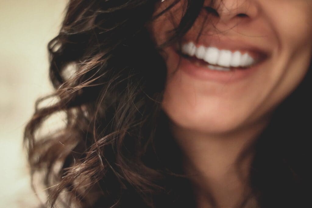 Woman smiling with bright white teeth after Zoom Whitening treatment