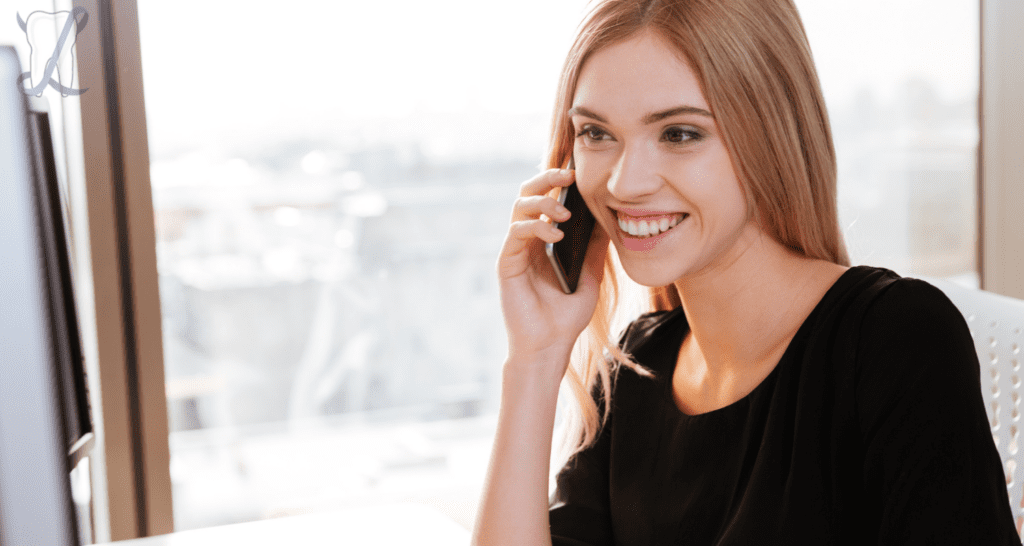 Woman talking on the phone and smiling after teeth whitening in Danvers