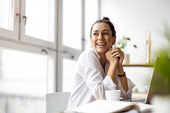 A smiling woman working at her desk