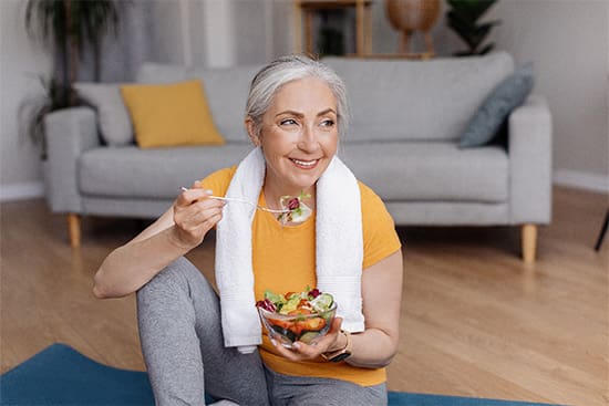 A woman eating a salad after doing yoga