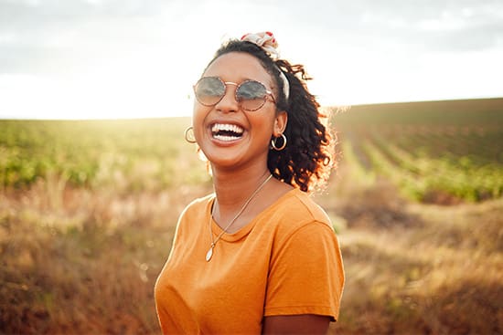 A woman standing in a field smiling