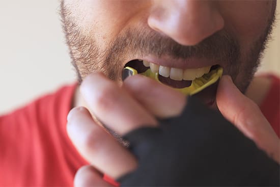 Patient in Danvers wearing a mouthguard to prevent dental emergencies