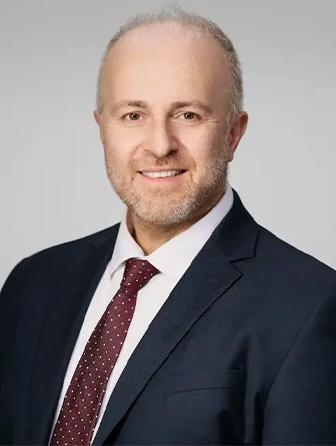 Profile image of Dr. Konstantinos Vazouras smiling in a suit and tie.