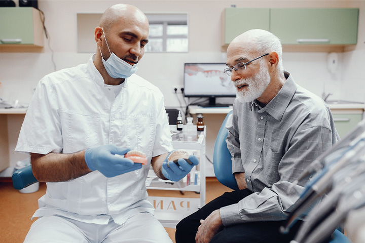 A dentist explaining to his patient how dentures work.