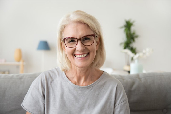 Lady smiles while trying on dentures.