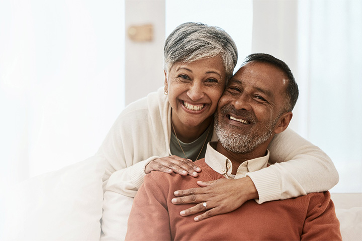 Middle aged couple smiling and hugging each other.