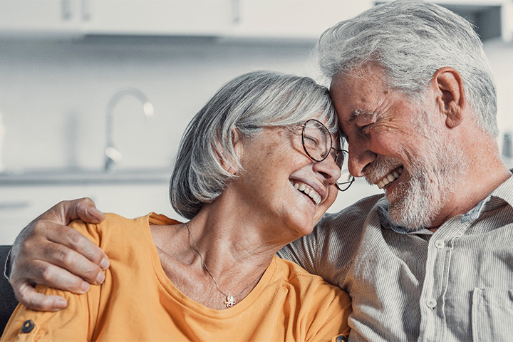Older couple hugging and smiling.