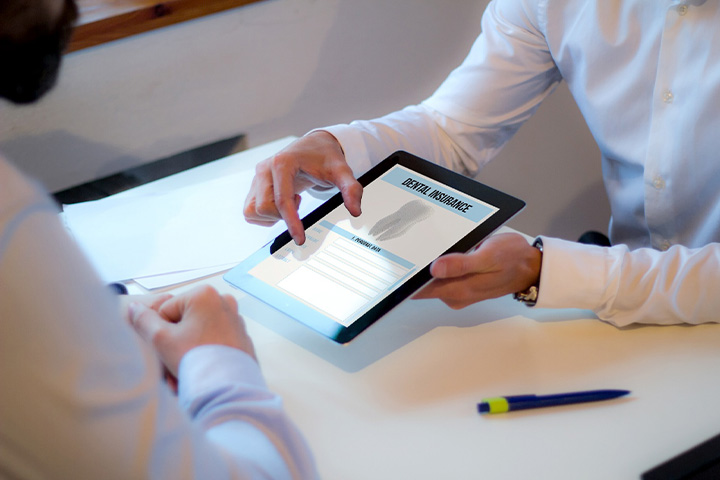 Patient looking at dental insurance form on tablet.