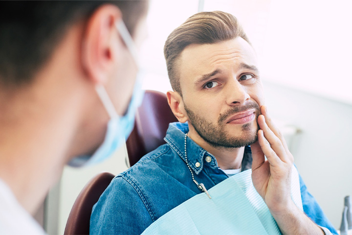 Patient with toothache looking at dentist.