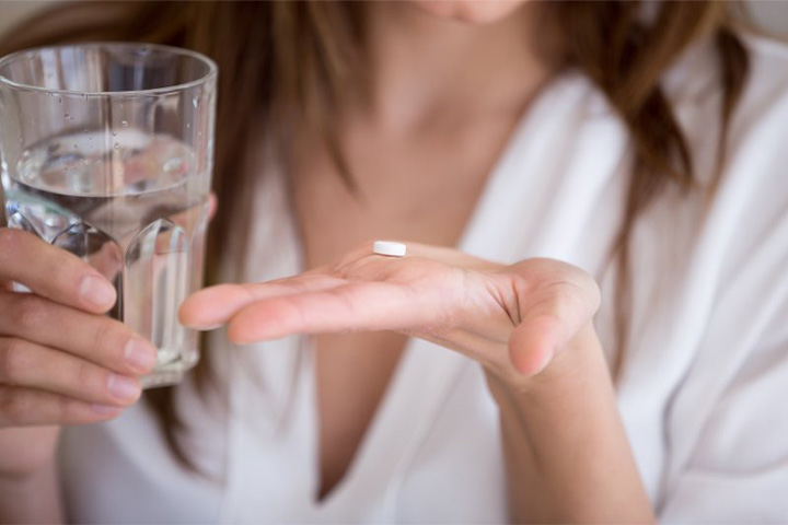 Lady prepares to take pill.