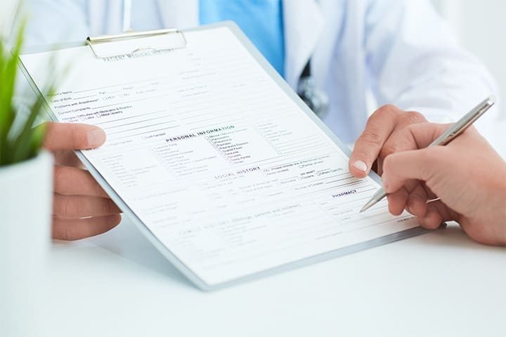 A patient smiling while sitting in a dental chair