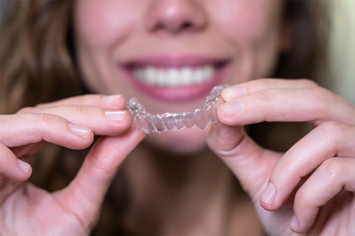 A patient holding their Invisalign tray.