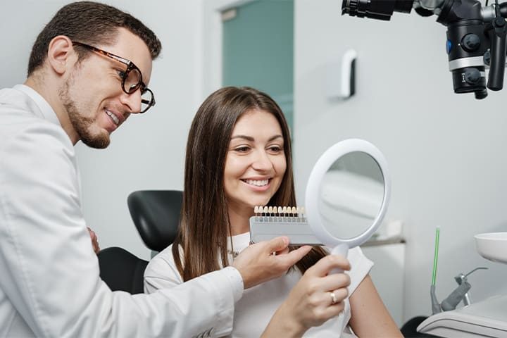 Dentist using shade guide to prepare for veneers